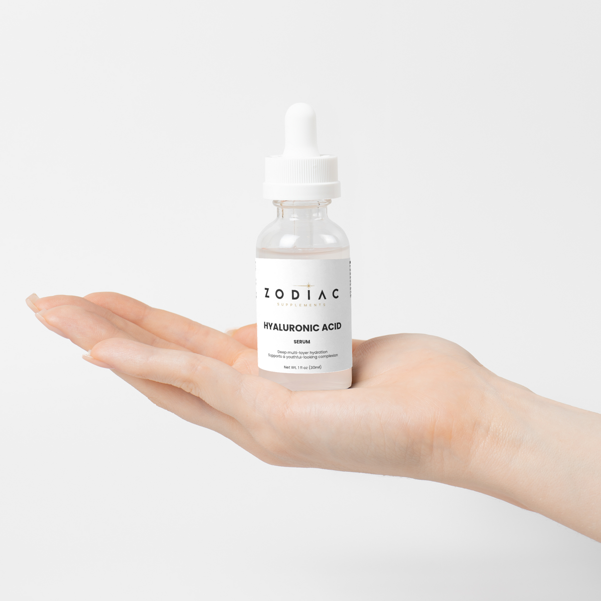 Hyaluronic Acid Serum in a dropper bottle held in a hand, showcasing skincare hydration.